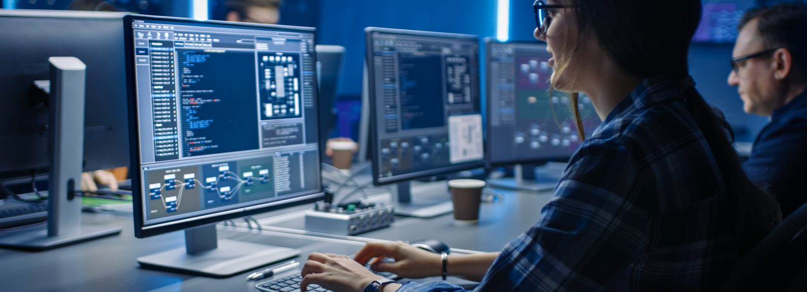 Smart Female IT Programer Working on Desktop Computer in Data Center System Control Room. Team of Young Professionals Doing Code Programming