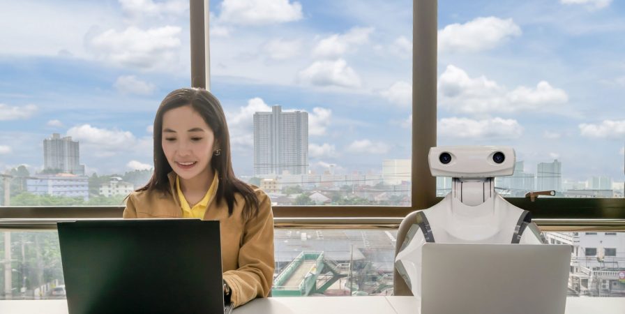 Working women and Robot computers in the office business RPA Robotic Process Automation